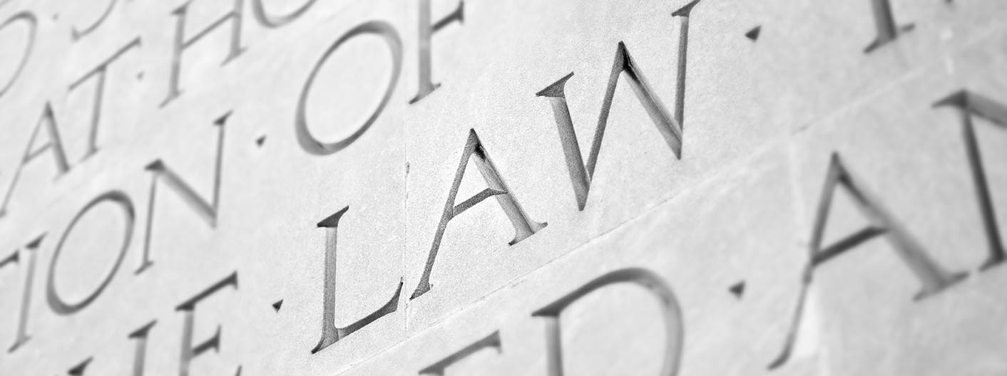 Engraved letters on a wall, featuring the word "law."