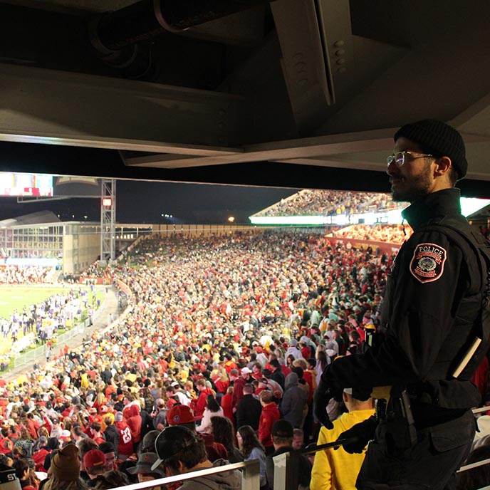 An ISU Police officer stands on the concourse during a Cyclone football night game.